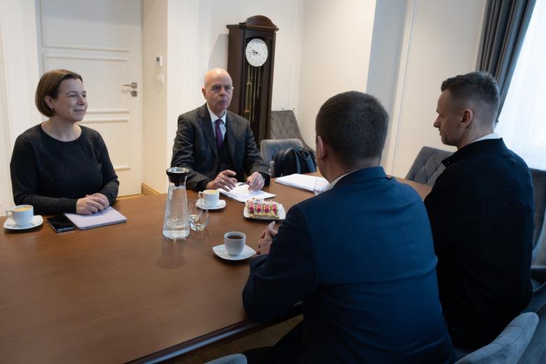 Cztery osoby siedzą przy stole i rozmawiają