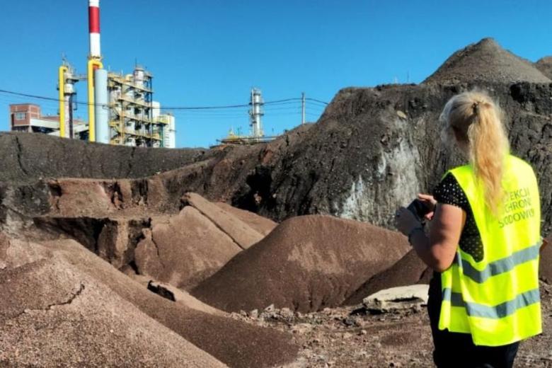 na pierwszym planie osoba odwrócona tyłem patrzy na hałdę pokopalnianą