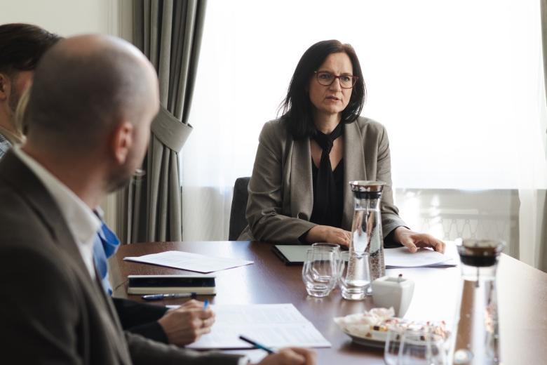 dwie osoby siedzą w sali, jedna patrzy na drugą