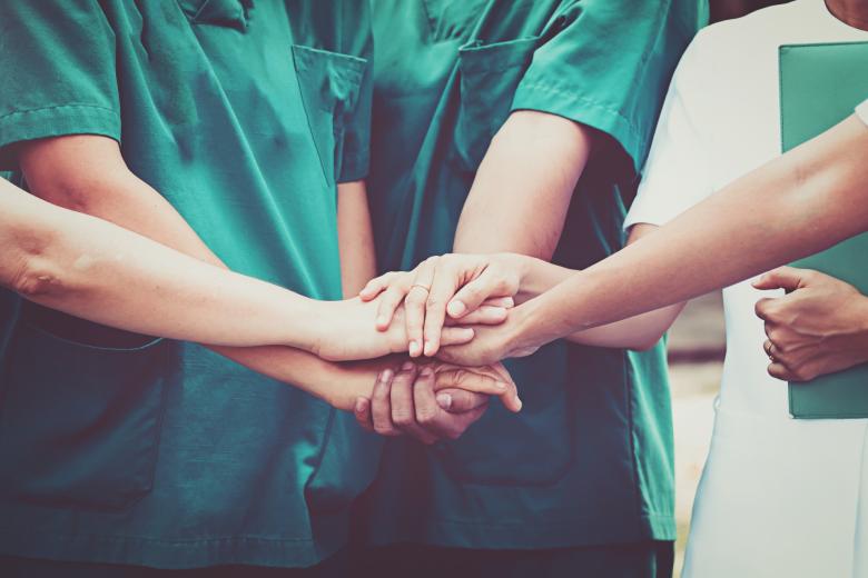 kilka kobiet w fartuchach, z dłońmi nałożonymi na siebie