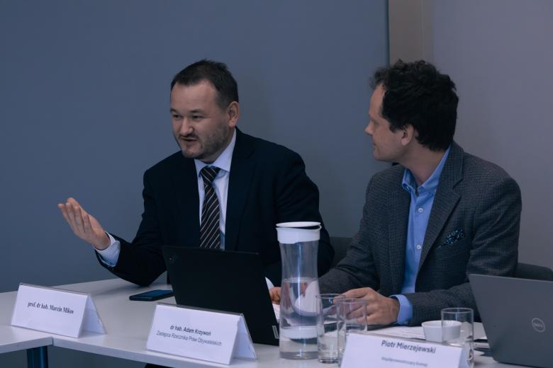 dwie osoby siedzą w sali 