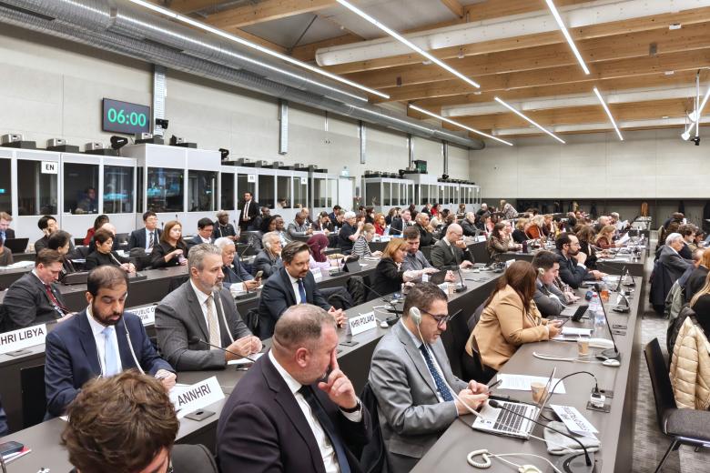 Kilkadziesiąt osób siedzi na dużej sali konferencyjnej