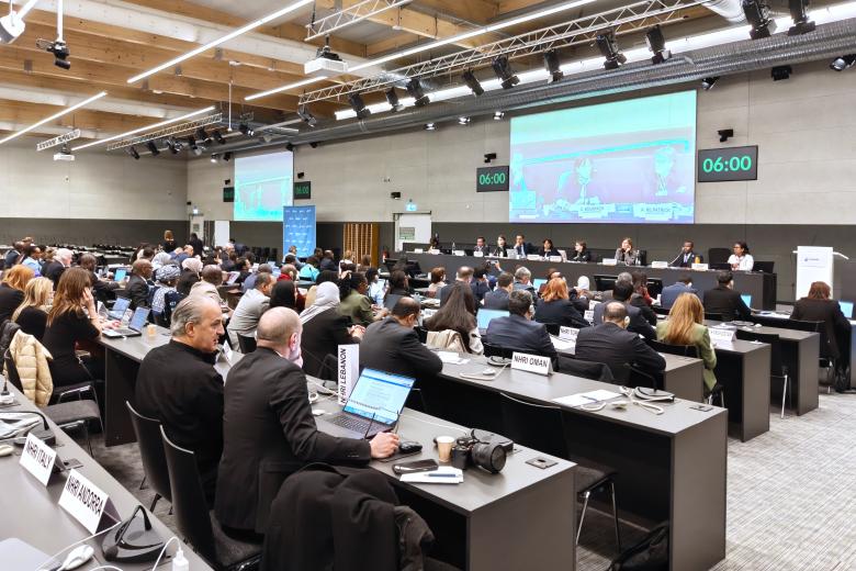 Kilkadziesiąt osób siedzi na dużej sali obrad