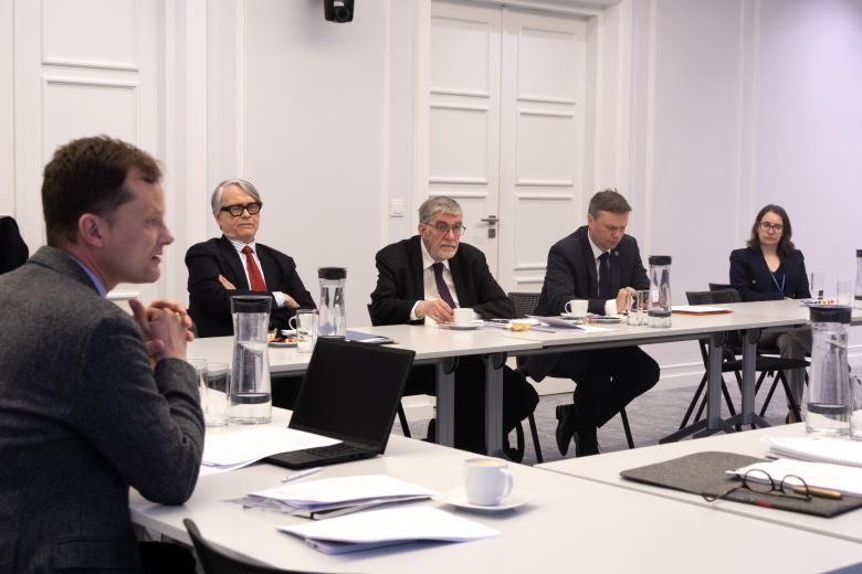 Cztery osoby siedzą za stołem na sali konferencyjnej