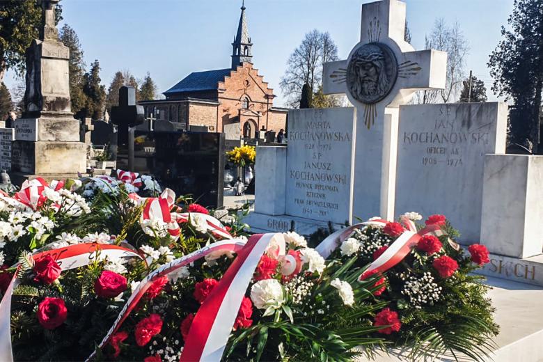grób na cmentarzu w wieńcach i kwiatach 