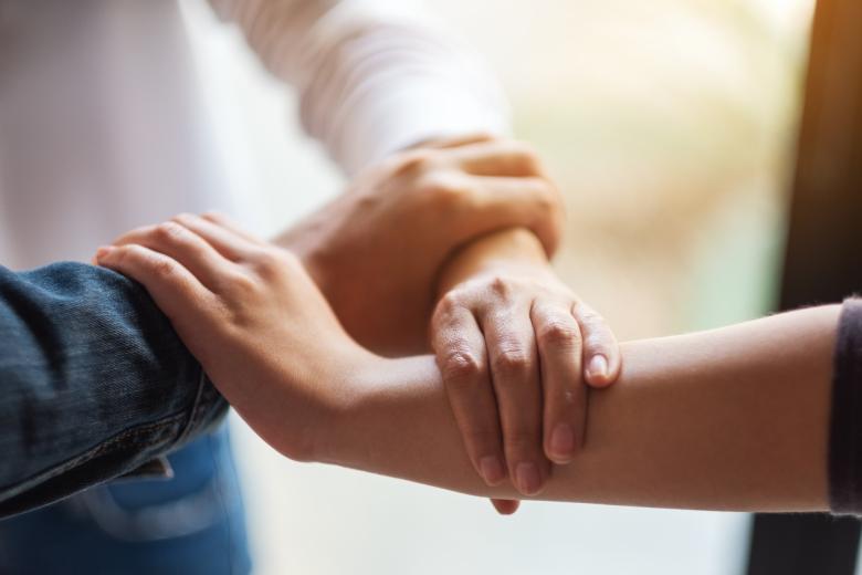 dwie osoby trzymają się za ręce
