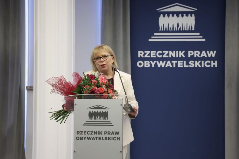 Osoba przemawia za mównicą z napisem "Rzecznik Praw Obywatelskich"