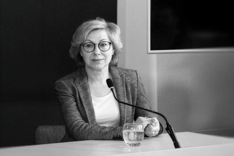 Czarno-białe zdjęcie Jolanty Florek siedzącej przy stole konferencyjnym