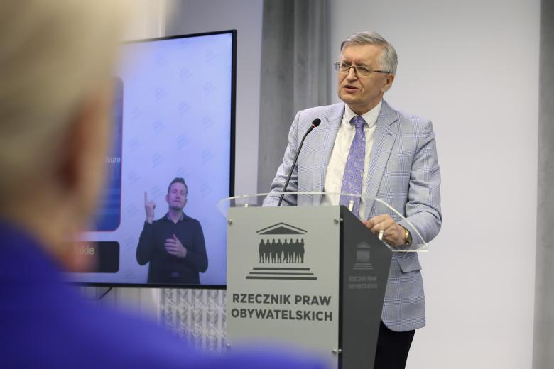 Osoba przemawia za mównicą z napisem "Rzecznik Praw Obywatelskich"