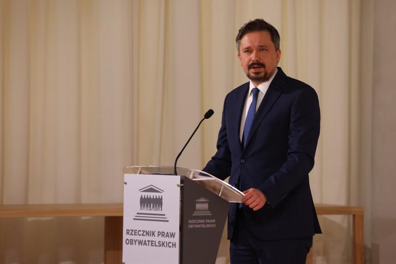 Marcin Wiącek wypowiada się stojąc przy mównicy