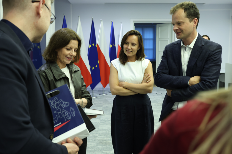 osoby w sali rozmawiają na stoją  