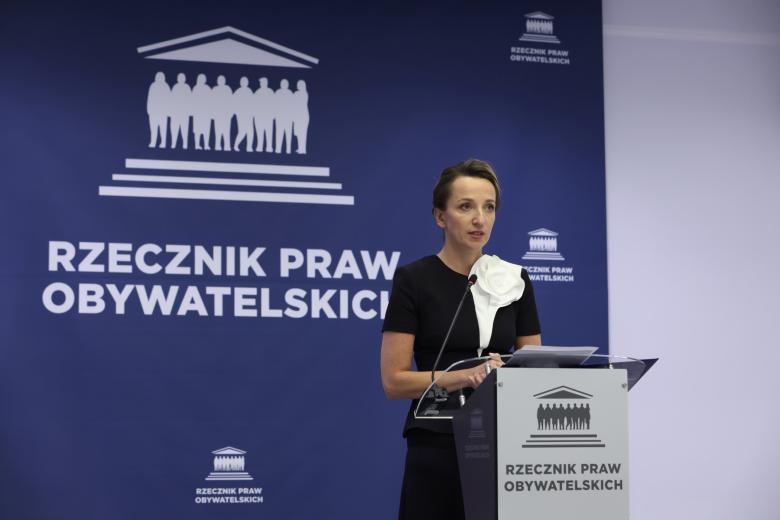 Osoba przemawia za mównicą z napisem "Rzecznik Praw Obywatelskich"