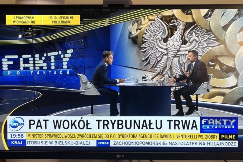 dwie osoby siedzą w studiu telewizyjnym 