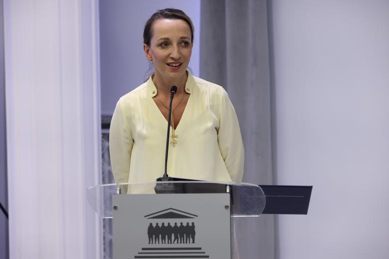 Sylwia Gregorczyk-Abram wypowiada się do stojąc przy mównicy w sali konferencyjnej