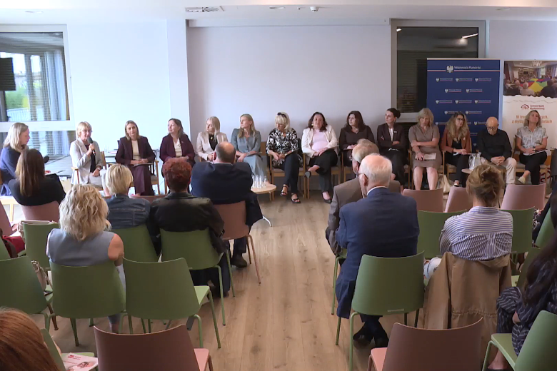 Kilkadziesiąt osób siedzi na sali konferencyjnej na spotkaniu