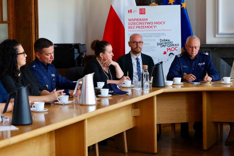 Kilka osób siedzi przy stole sali narad urzędu