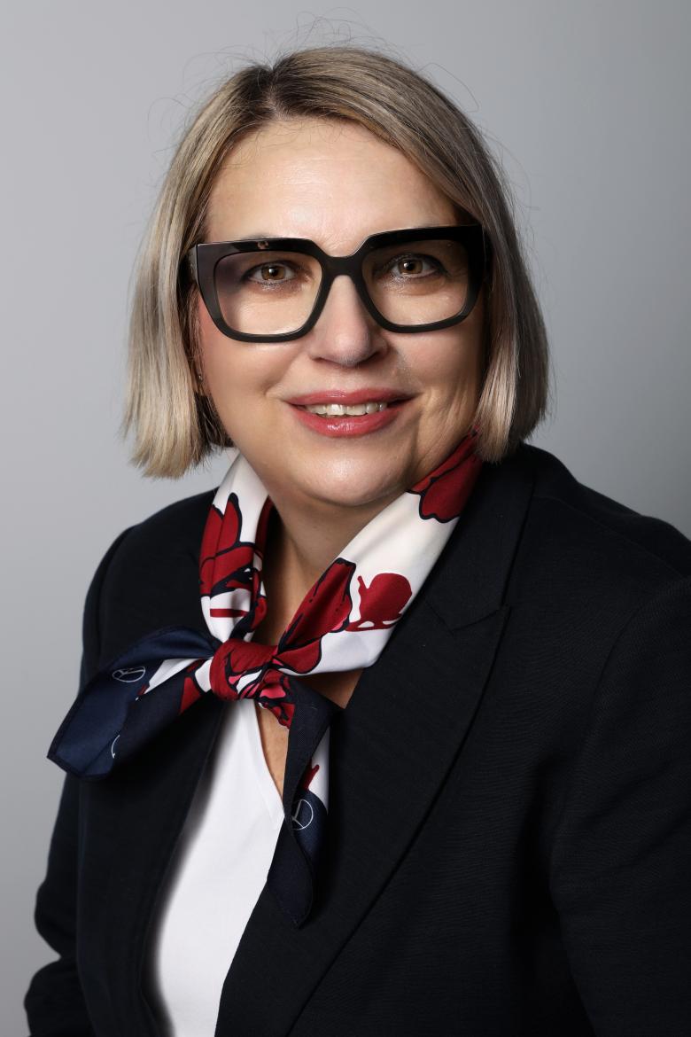 Portret Moniki Okrasy - uśmiechnięta kobieta w okularach