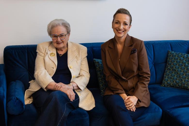 Ewa Łętowska i Sylwia Gregorczyk-Abram uśmiechają się, pozując do zdjęcia na kanapie