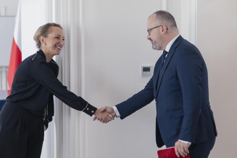 Sylwia Gregorczyk-Abram i Adam Bodnar witają się uściskiem dłoni, uśmiechając się