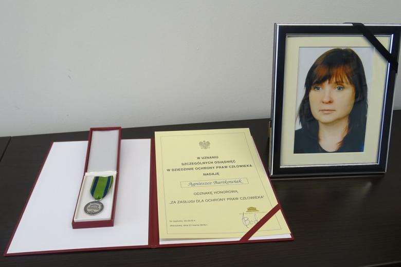 Zdjęcie dyplomu i fotografii młodej kobiety z żałobną obwódką