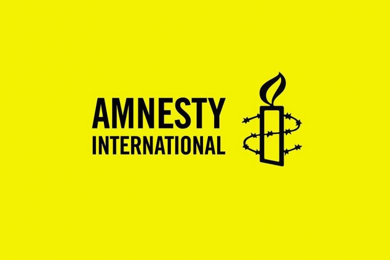 Logo Amnesty International na żółtym tle