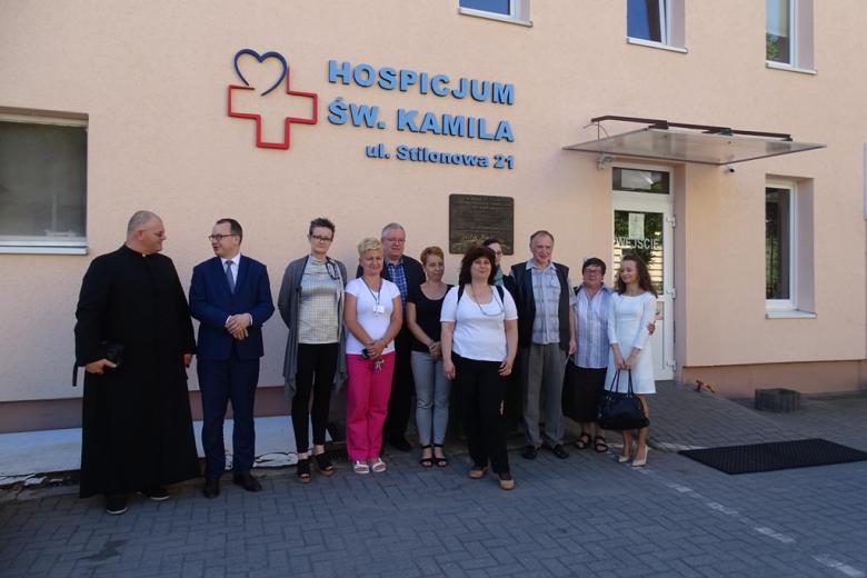 Ludzie przed hospicjum, w tym ksiądz