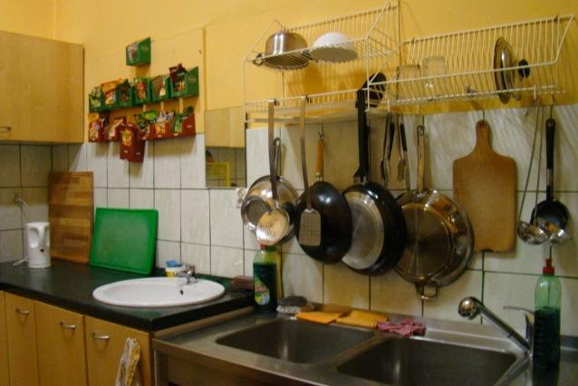 zdjęcie: zlew kuchenny, nad nim wiszą patelni i deski do krojenia
