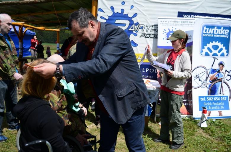 zdjęcie: mężczyzna zawiesza medal na szyi kobiety na wózku inwalidzkim