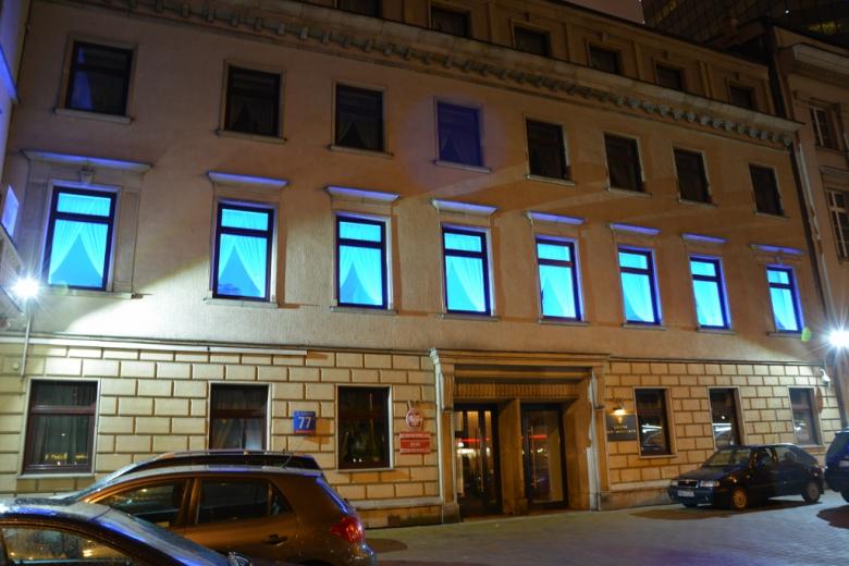 Zdjęcie: zbliżenie na budynek Biura RPO przy Al. Solidarności 77 w Warszawie, na pierwszym piętrze podświetlone na niebiesko okna