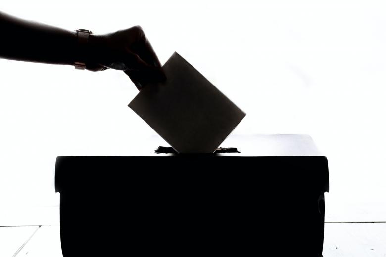 Grafika z osobą wrzucającą głos do urny 