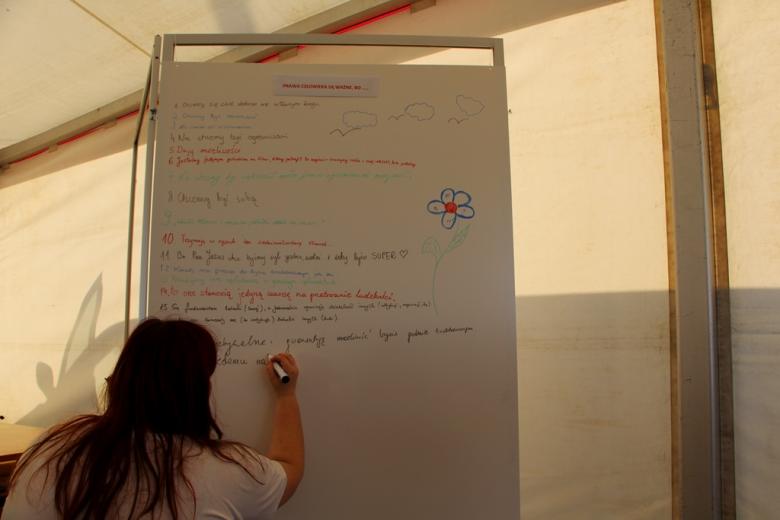 zdjęcie: przy białej tablicy stoi dziewczyna, która na niej pisze