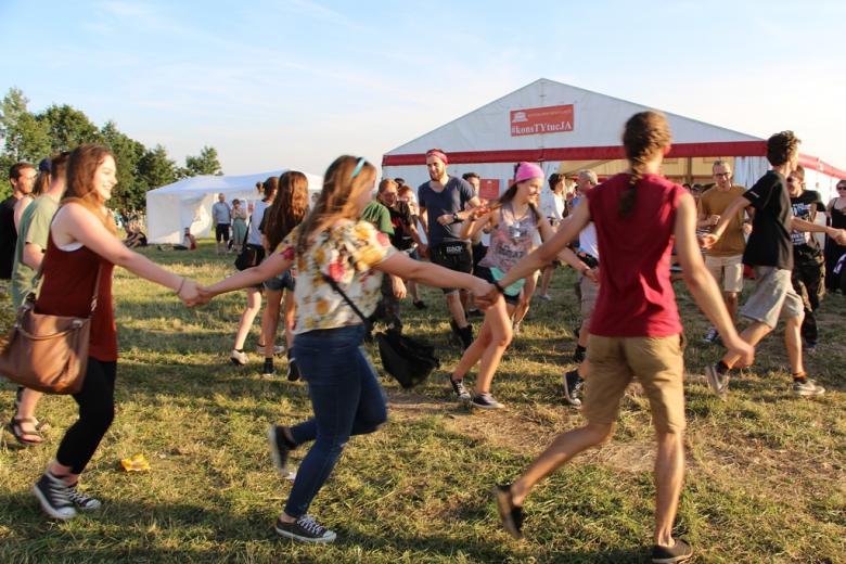 zdjęcie: kilkanaście osób tańczy w kręgu trzymając się za ręce