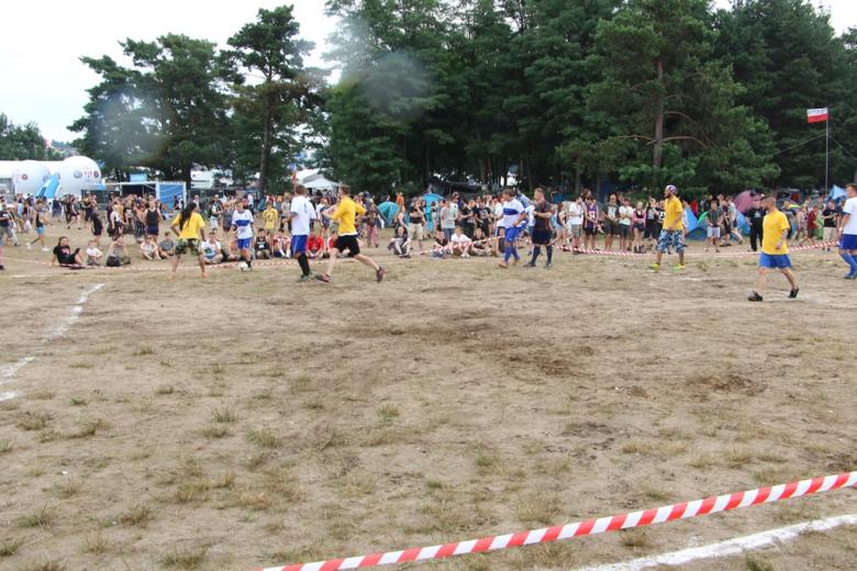 zdjęcie: kilkanaście osób gra na wyznaczonym na ziemi boisku