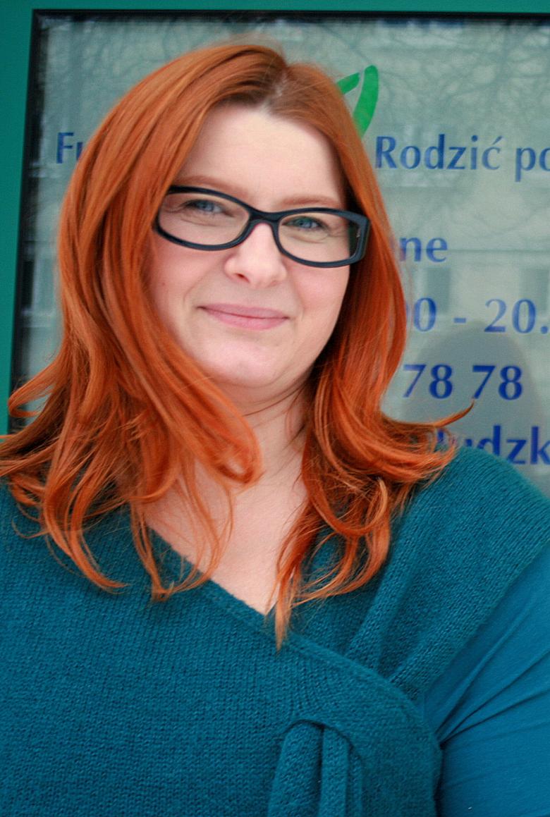 Kobieta w okularach z długimi rudymi włosami