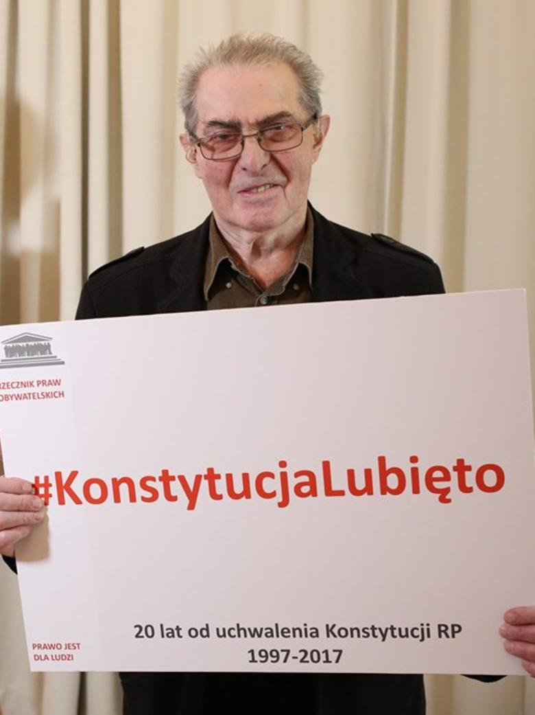 Mężczyzna trzyma tablice z napisem #KonstytucjaLubieTo