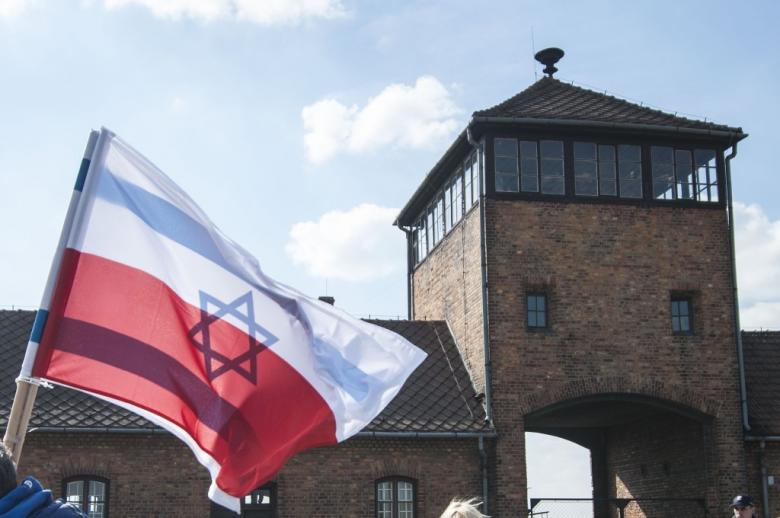 flaga polska i izraelska na tle byłego niemieckiego obozu zagłady 