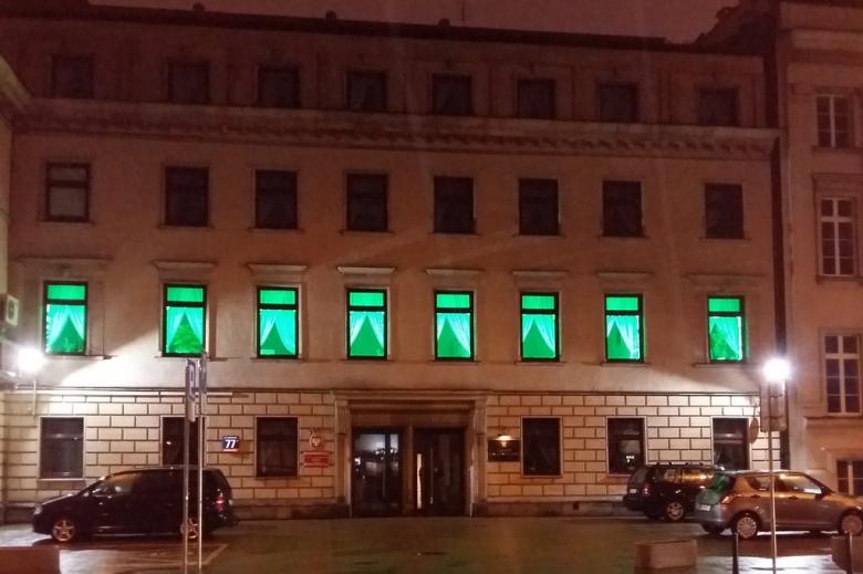 zdjęcie: budynek w którym okna na pierwszym piętrze podświetlone są na zielono