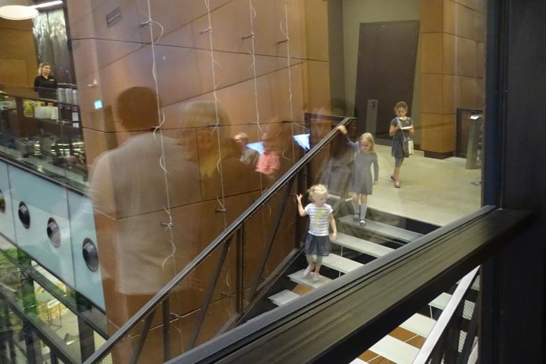 Zdjęcie: trzy małe dziewczynki schodzą po schodach w nowoczesnym wnętrzu
