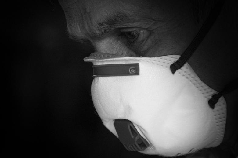 Czarno-białe zdjęcie człowieka z twarzą zasłoniętą maską