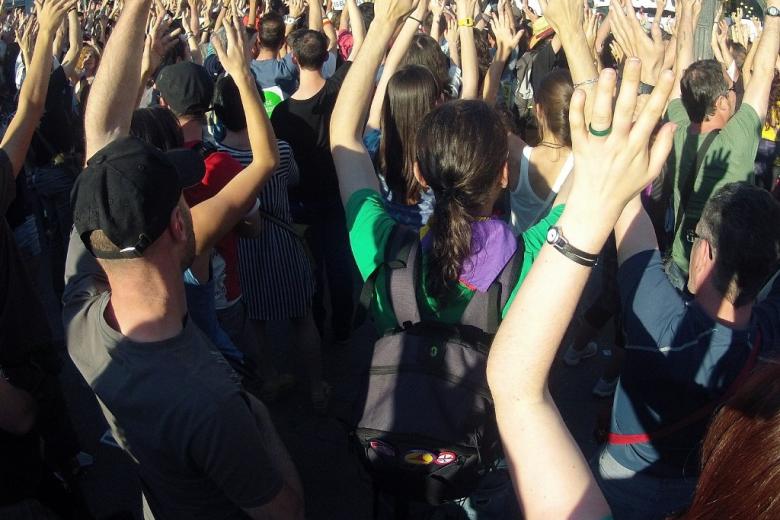Ludzie w czasie zgromadzenia wznoszą ręce