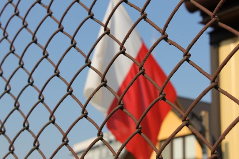 Polska flaga za siatką ogrodzenia