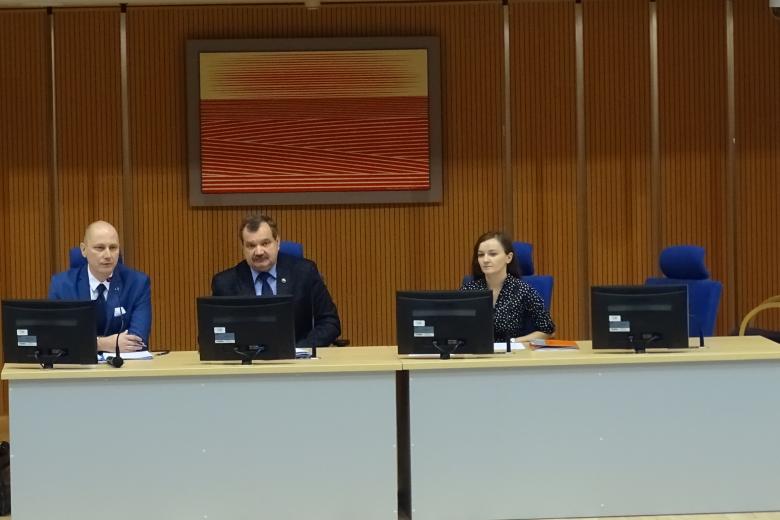 Zdjęcie: dwaj mężczyźni i kobieta za stolem prezydialnym