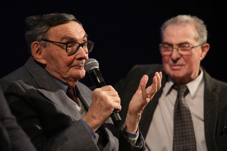 zdjęcie: dwaj starsi mężczyźni, jeden z nich mówi do mikrofonu