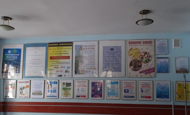 Plakaty i dyplomy na ścianie