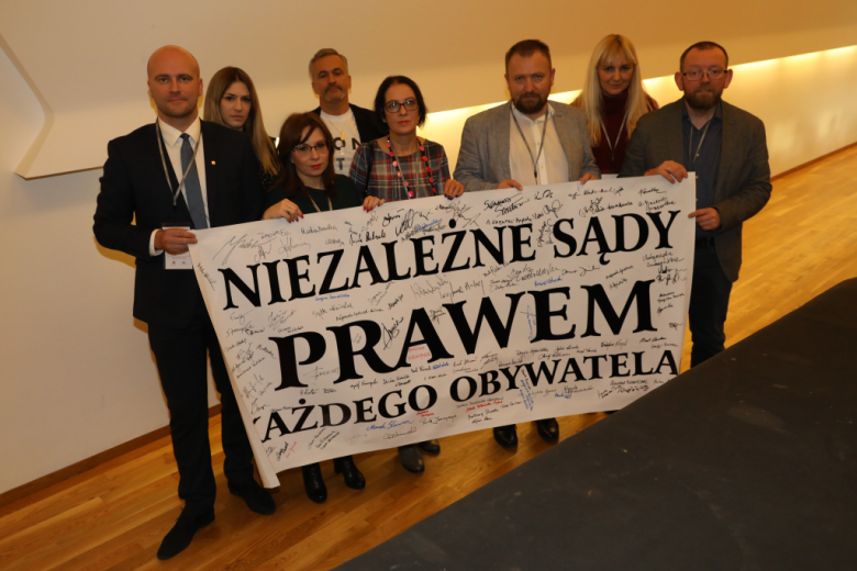 Ludzie trzymają transparent "Niezależne sądy prawem"