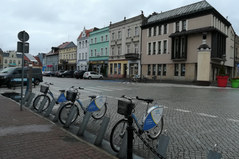 Stojak rowerów miejskich na rynku z piętrowymi kamieniczkami