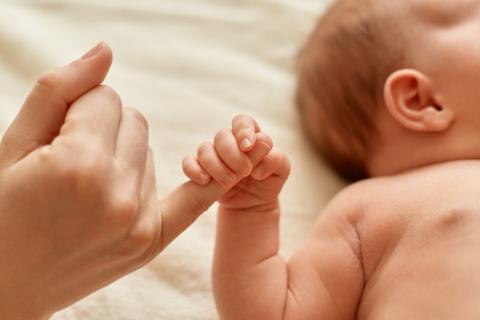 noworodek trzyma dłoń dorosłej osoby