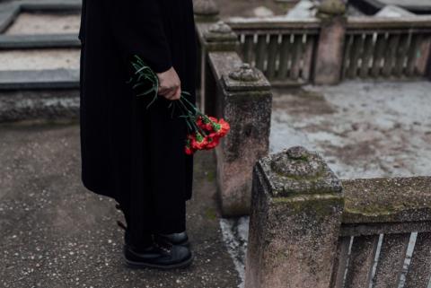 osoba z kwiatami na cmentarzu 