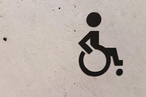 Grafika z symbolem osoby z niepełnosprawnością na wózku