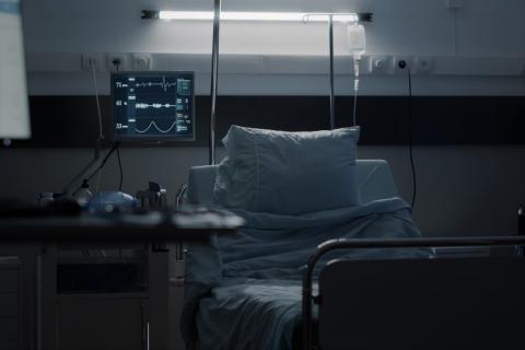 zdjęcie pustego łóżka szpitalnego w ciemnej sali 